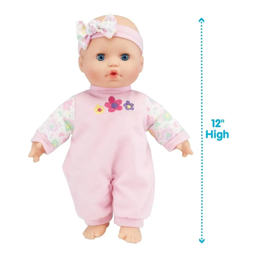 Kidoozie Sweetie Doll with blue eyes and pink floral outfit stands upright with matching bow headband, shown next to measurement text indicating the doll is 12 inches tall.