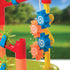 Close-up of blue and orange spiral-patterned plastic water wheels from the Kidoozie Water Tower Playset, spinning as water pours down against a green outdoor background.