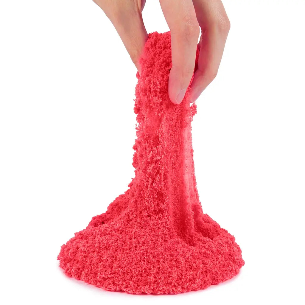 kinetic sand neon red sand bright red fine-grain crumbly texture stretched by fingers into a soft flowing form for sensory play, shown against a clean white background
