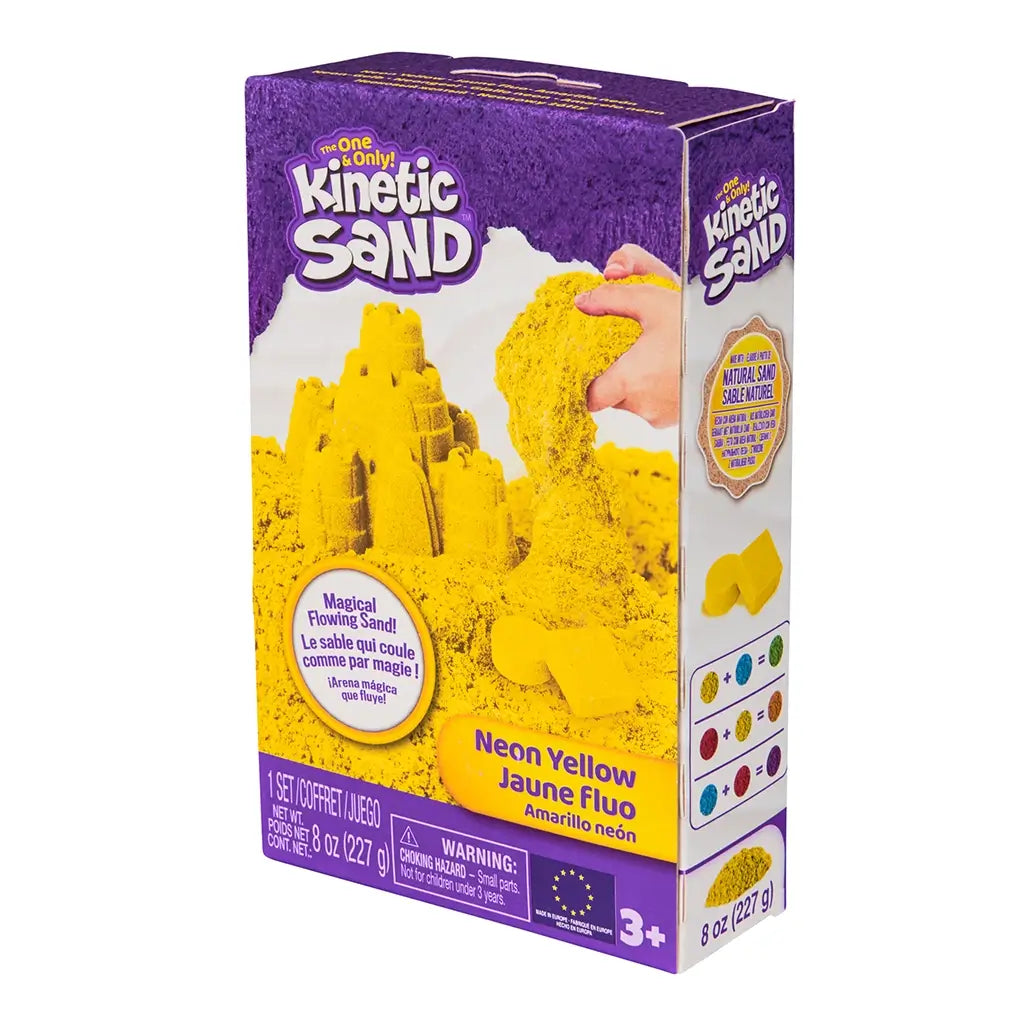 Kinetic Sand neon yellow sand product box purple cardboard rectangular angled package displaying molded yellow sand castle and pouring sand action for creative sensory play, on white background