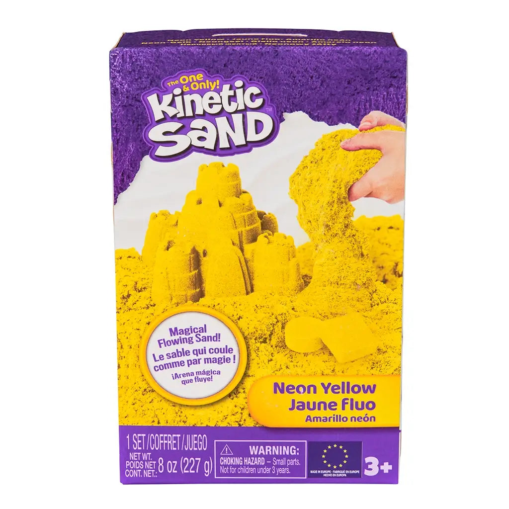 Kinetic Sand neon yellow sand product box purple cardboard rectangular front showing bright yellow sand castle and flowing texture for kids sensory play, set on a clean white background