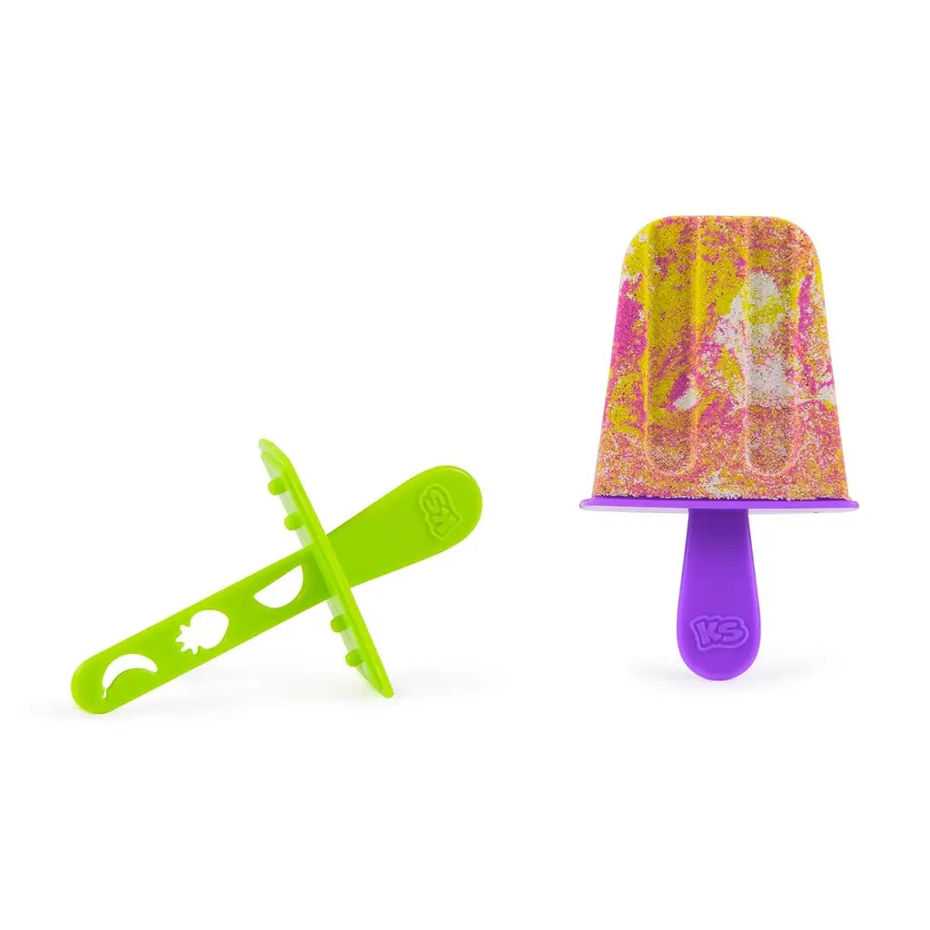 Mixed yellow, pink, and white Kinetic Sand popsicle with speckled blended texture, displayed beside green and purple stick molds, highlighting creative color mixing on a clean white background.