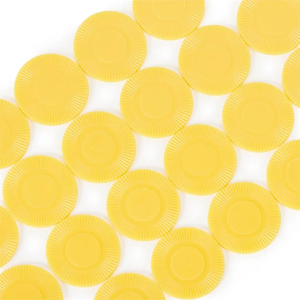 Left Center Right game chips in bright yellow molded plastic with ridged edges and circular shape, spread across a white surface in a neat overlapping pattern.