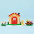 LEGO Animal Crossing Goldie's Cozy House playset displays the tan cottage, Goldie figure, mailbox and picnic table arranged on a light blue surface with detailed LEGO elements and realistic display presentation.