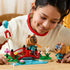 LEGO Animal Crossing Timmy & Tommy playset in red, green, blue, brown, and pink plastic is explored by a child arranging two figures around a flower-lined bridge and stream.