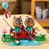 LEGO Animal Crossing Timmy & Tommy playset in red, green, blue, and brown plastic displays two raccoon figures on a curved bridge with flowers, stream, fishing rod, and balloon gift.