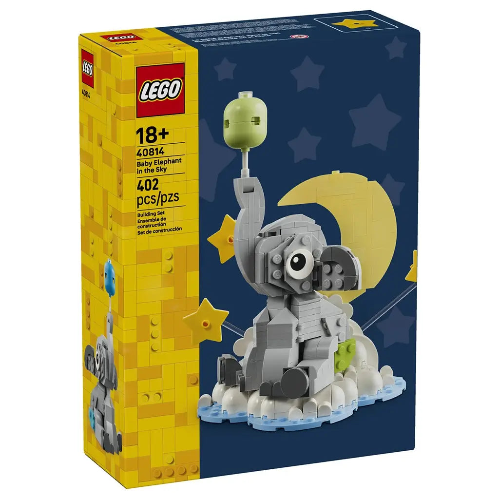 LEGO baby elephant display set with yellow and navy cardboard packaging, featuring a gray brick-built elephant holding a balloon, framed by moon, stars and clouds on a night-sky themed background.