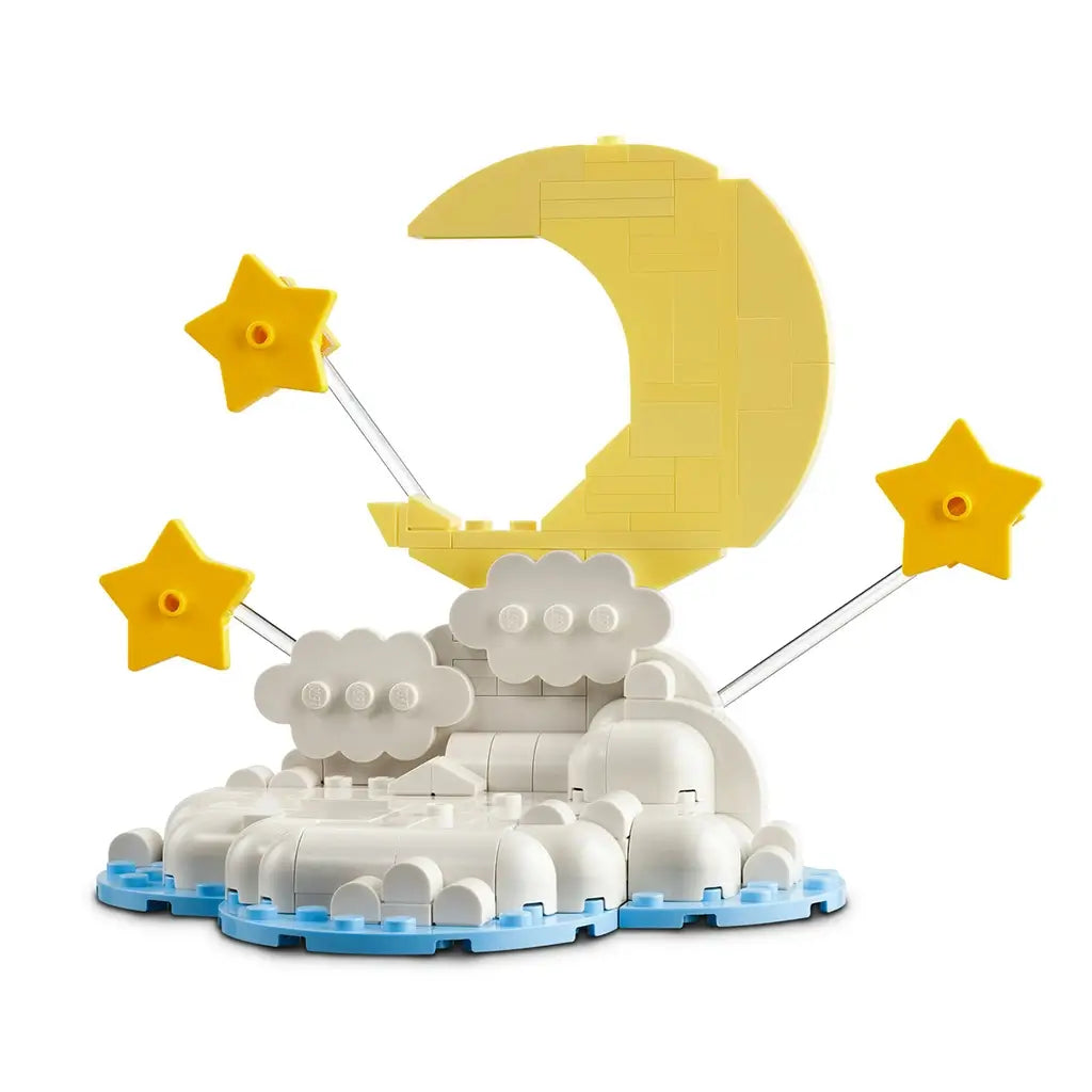 LEGO baby elephant display built from gray, white, yellow and blue plastic bricks, featuring a rounded elephant figure, balloon, crescent moon, stars and cloud base on a plain background.