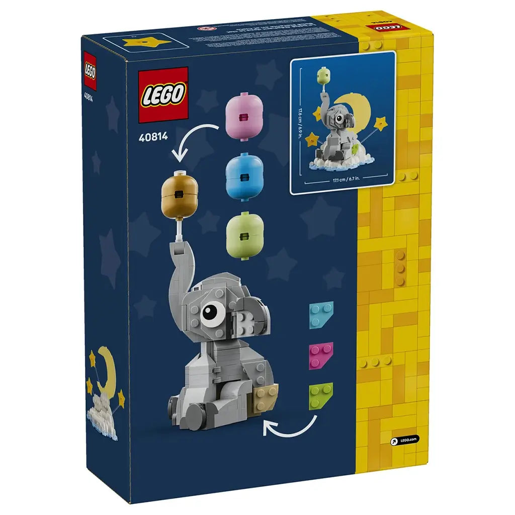 LEGO baby elephant display packaging showing navy and yellow cardboard panels, gray elephant model with interchangeable balloon colors and decorative accent options on a starry studio background.