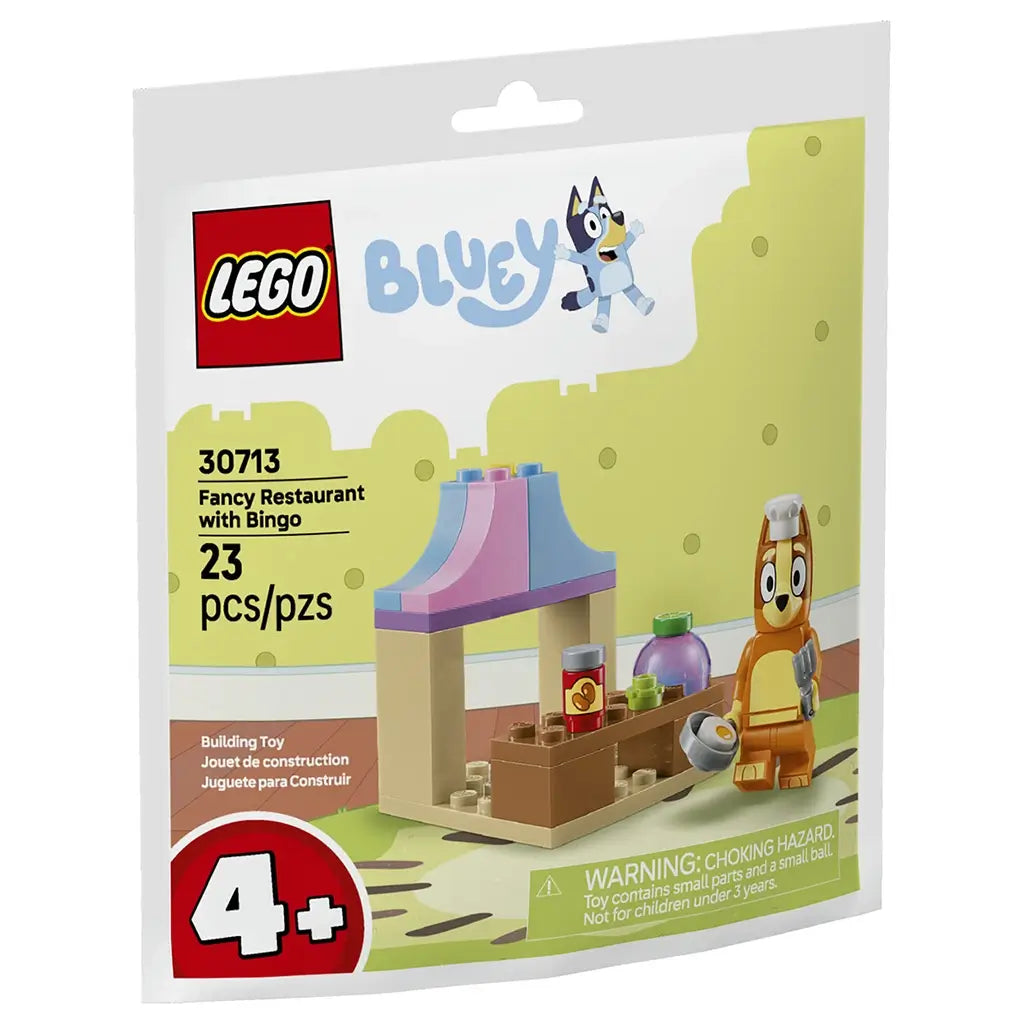LEGO Bluey restaurant playset in cream, brown, pink and light blue plastic bricks, shaped as a small café counter with food accessories and Bingo character chef, shown on retail pouch artwork.