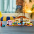 LEGO Bluey School set in tan, brown, pink, purple, and teal plastic forms a classroom play scene with Bluey and Rusty figures, a stroller, beds, tables, and kitchen details.