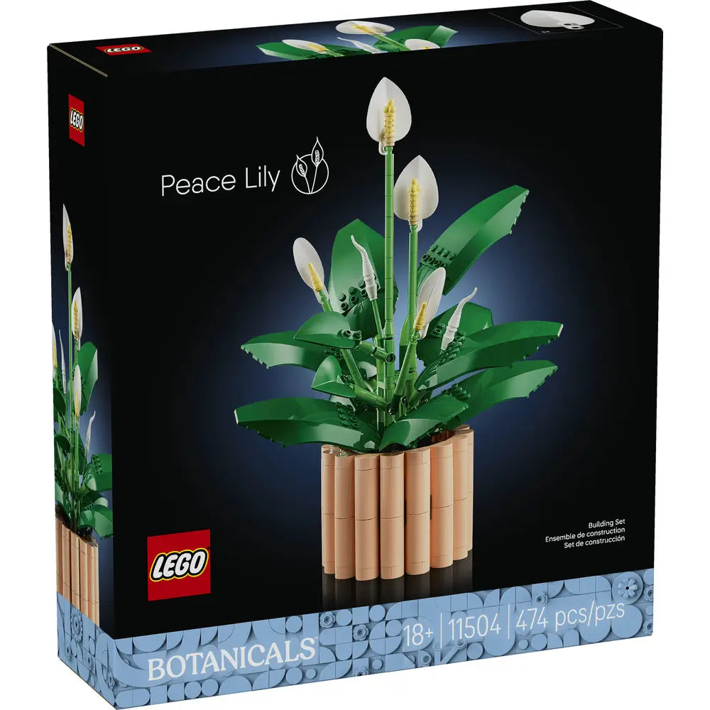 LEGO Botanicals Peace Lily box front with black packaging showing green leaf clusters and white peace lily blooms, detailed plastic brick botanical model for adult decorative display, photographed against a dark studio background.