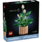 LEGO Botanicals Peace Lily box front with black packaging showing green leaf clusters and white peace lily blooms, detailed plastic brick botanical model for adult decorative display, photographed against a dark studio background.