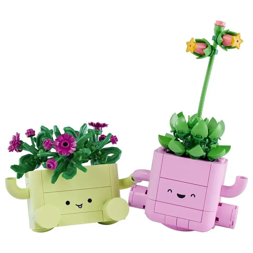 LEGO Botanicals Rocking Plants set in pink and light green bricks shows two smiling planters with green foliage and colorful flowers as a child watches them on a table.