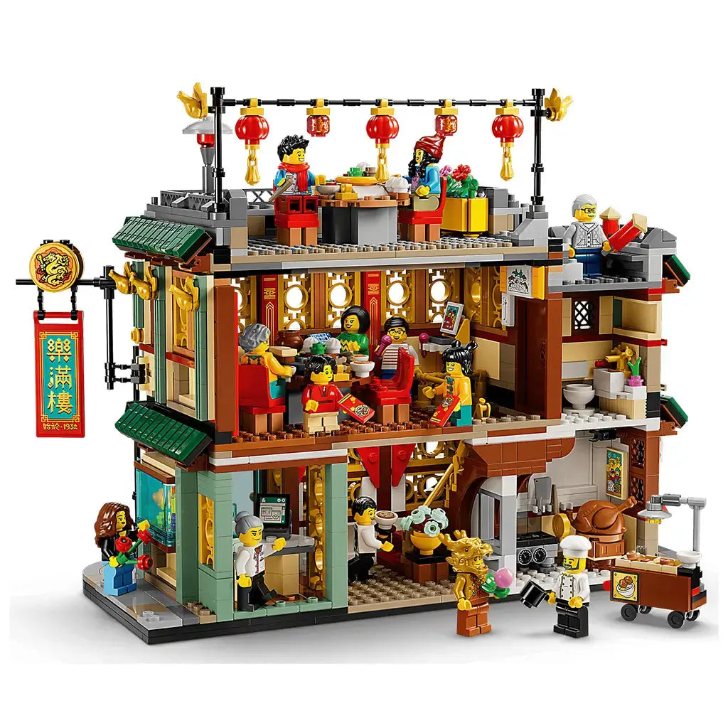 LEGO Spring Festival restaurant in green, red, gold and tan plastic is opened to reveal rooftop and indoor dining, a ground-floor kitchen and 13 minifigures on white.