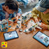 LEGO City airport building set shown in use by children, featuring colorful plastic airplane and terminal pieces spread on a wooden table, encouraging hands-on construction and creative play.