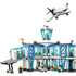 LEGO City airport playset featuring white and blue plastic modular buildings with clear windows, control tower, jet bridge, and passenger airplane, designed for imaginative airport travel play.