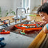 LEGO City lifestyle image of a child playing with the Coast Guard rescue boat in a kitchen sink, demonstrating floating play, rescue scenarios, and hands-on imaginative water-based fun at home.