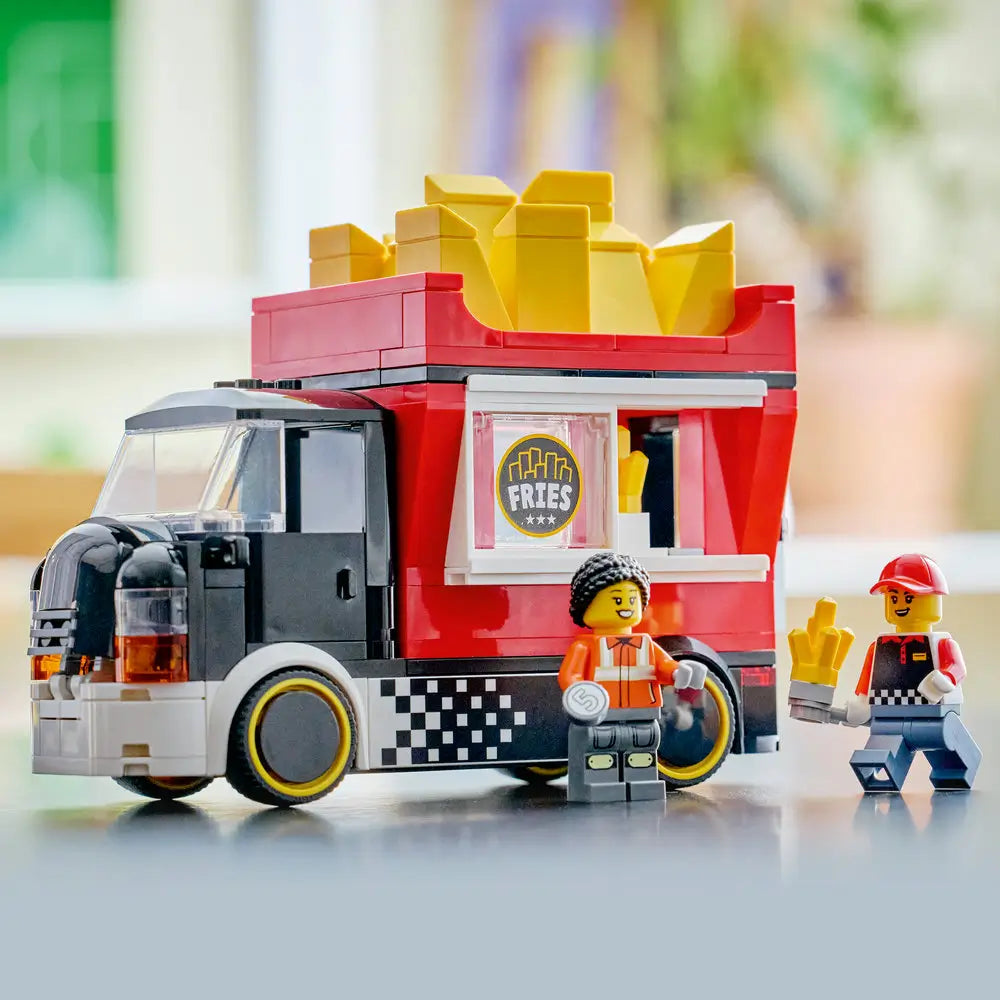 LEGO City fries food truck display image showing the finished red and black truck with yellow fries roof, serving window, two minifigures, and clean tabletop background highlighting details.