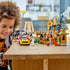 LEGO City Pizza Delivery Experience in yellow, brown, red, and green plastic bricks is played with by a smiling child, with a pizza shop, sports car, scooter, and minifigures.