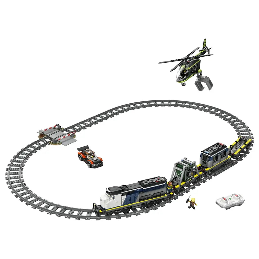 LEGO City police train build in blue and gray plastic, long circular track with locomotive, cargo cars, helicopter, and car, action toy layout on a clean white background.