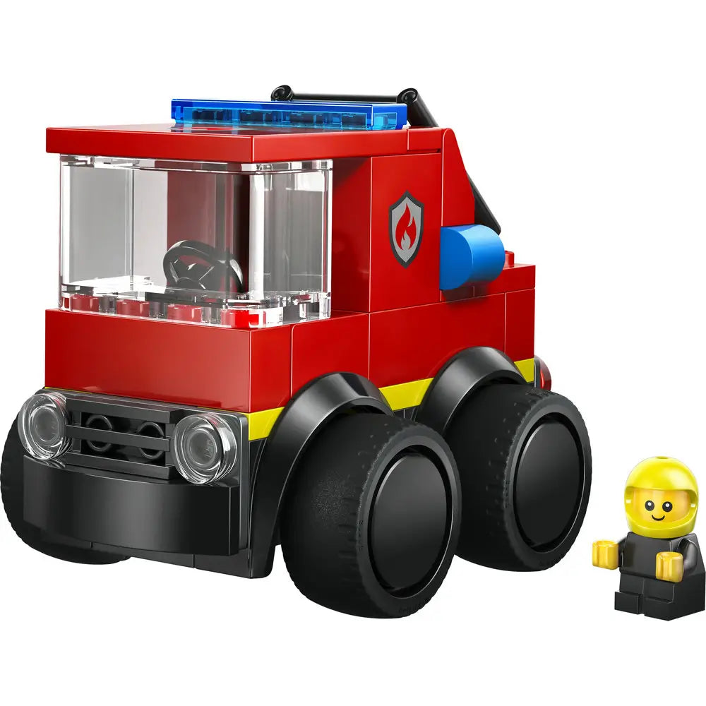 LEGO City Fire Truck built from bright red plastic bricks with yellow accents, compact boxy cab, clear windshield, blue light bar, hose detail, six chunky wheels, and a firefighter minifigure on a white background.