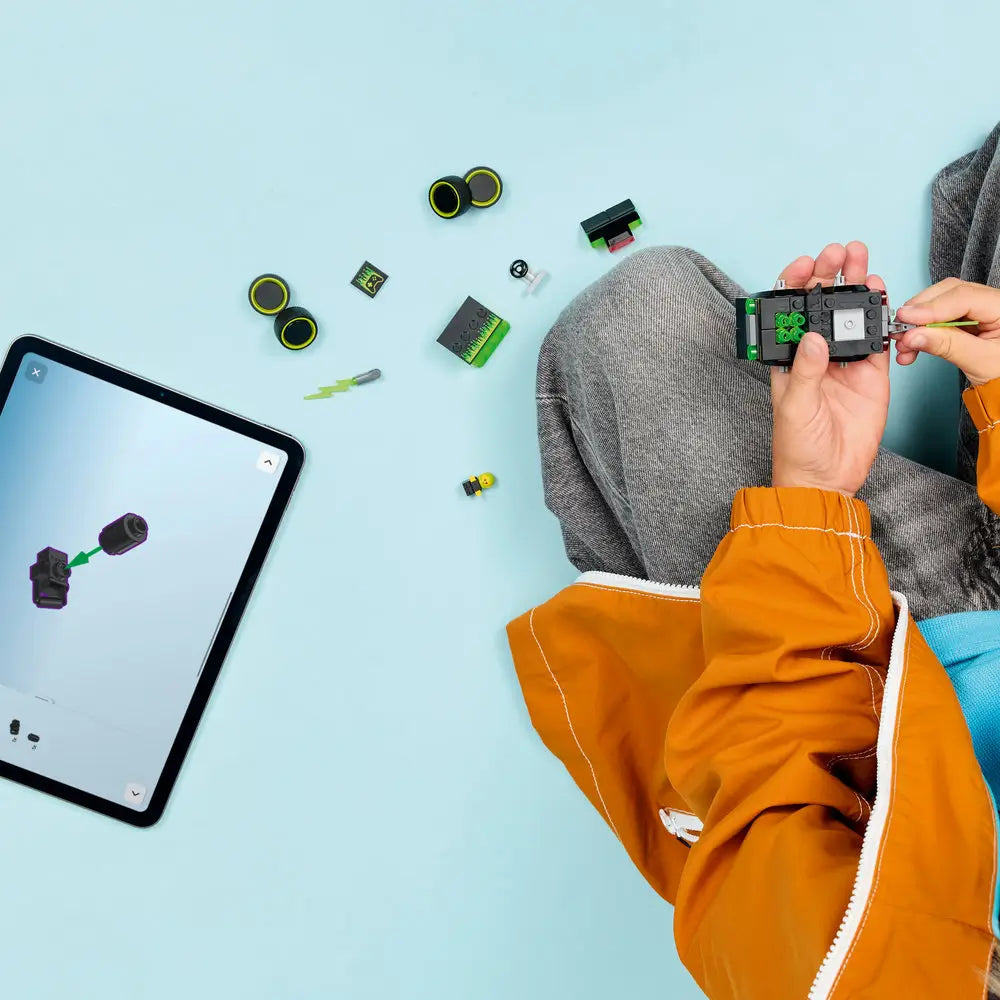 LEGO City Gaming Car partially assembled from black and neon green plastic bricks, compact square body, with loose pieces spread out as a child follows step-by-step digital building instructions on a tablet.