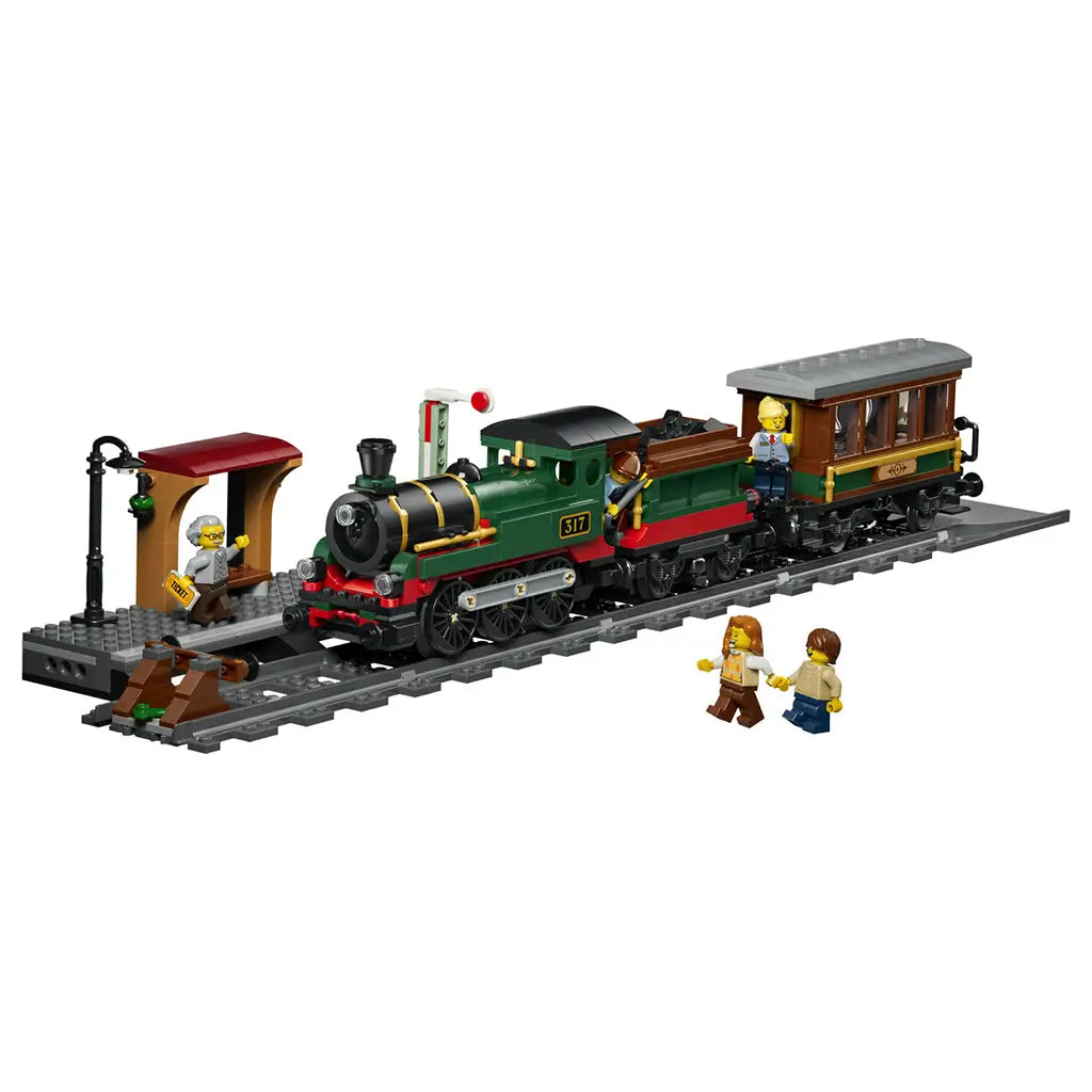 LEGO City Vintage Steam Train in green, black, red, brown, and gray plastic bricks features a locomotive, passenger car, station platform, track, signal, and minifigures.