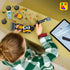 LEGO City Backhoe Loader building toy in yellow and black plastic is assembled by a child beside loose parts and a tablet displaying digital LEGO instructions.
