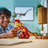 LEGO Creator dinosaur toy in red and yellow plastic bricks as a child plays with the assembled dinosaur figure, emphasizing scale, articulated joints, expressive pose, and imaginative indoor prehistoric play.