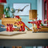 LEGO Creator 3-in-1 dinosaur models displayed together on a tabletop, showing a dinosaur, alternate creature builds, and accessories made from smooth red and yellow plastic bricks in a bright indoor setting.