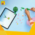 LEGO Creator turtle building set arranged on a light blue surface, showing green plastic bricks, a partially assembled turtle model, scattered leaf and flower pieces, and a tablet displaying digital step-by-step building instructions.