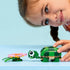LEGO Creator turtle toy in green plastic bricks as a child gently plays with the turtle and pink water lily, highlighting scale, rounded shapes, and imaginative indoor nature-themed play.