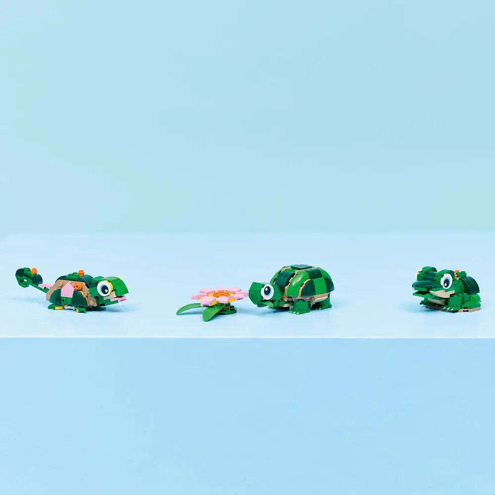 LEGO Creator 3-in-1 animal models displayed together on a clean surface, showing a turtle, alternate reptile build, and frog made from green plastic bricks with small nature accessories.