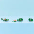 LEGO Creator 3-in-1 animal models displayed together on a clean surface, showing a turtle, alternate reptile build, and frog made from green plastic bricks with small nature accessories.
