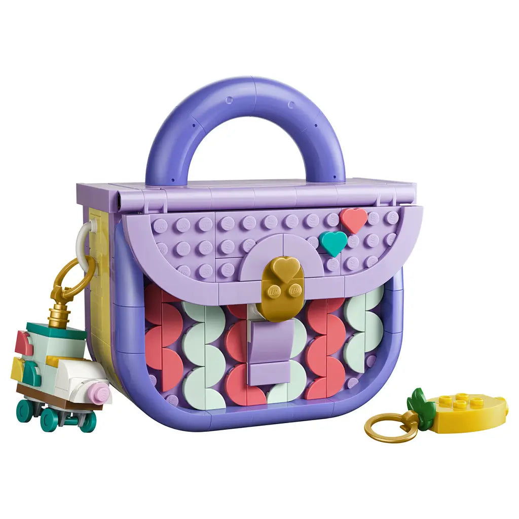 LEGO Creator Fashion Bag 31391 in lavender, purple, coral and mint plastic, shaped as a handbag with heart details, gold clasp, roller skate charm and yellow key charm on white.