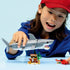 LEGO Creator shark toy in gray plastic bricks as a child holds and plays with the shark above a small treasure chest scene, emphasizing scale, angular shapes, and imaginative indoor ocean play.