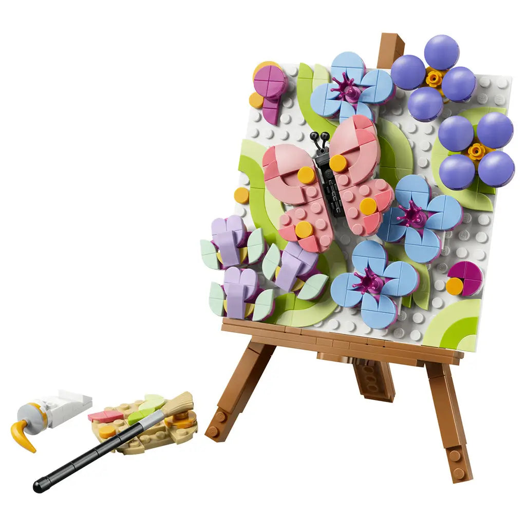 LEGO Creator Floral Art 31390 in pink, blue, green and purple plastic, shaped as a square butterfly and flower painting on a brown easel with brush, palette and paint tube.
