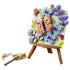 LEGO Creator Floral Art 31390 in pink, blue, green and purple plastic, shaped as a square butterfly and flower painting on a brown easel with brush, palette and paint tube.