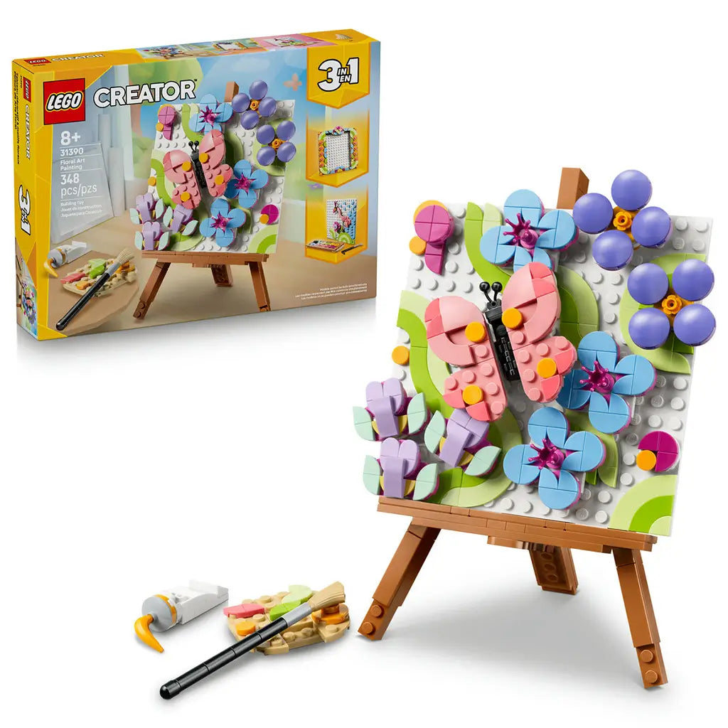 LEGO Creator Floral Art 31390 in pink, blue, green and purple plastic, displayed with its retail box as a butterfly and flower painting on a brown easel with art tools.