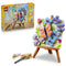 LEGO Creator Floral Art 31390 in pink, blue, green and purple plastic, displayed with its retail box as a butterfly and flower painting on a brown easel with art tools.