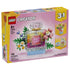 LEGO Creator 3-in-1 set 31383 box front in pink and yellow shows the clear plastic brick Floral Perfume Bottle with pink flowers, green leaves, and blue base.