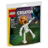 LEGO Creator Halloween skeleton building set in orange, white, black and green plastic bricks, shaped as a pumpkin-headed skeleton holding a lantern, displayed on festive retail pouch artwork with a spooky night backdrop.