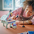 LEGO Creator Music Decor Piano in mint, purple and pink plastic, with a person posing a black cat beside the grand piano, colorful keys, stool and microphone on a table.