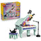 LEGO Creator Music Decor Piano 31392 in mint, purple and pink plastic, with a grand piano, colorful keys, sheet music, black cat, stool and microphone beside the retail box.