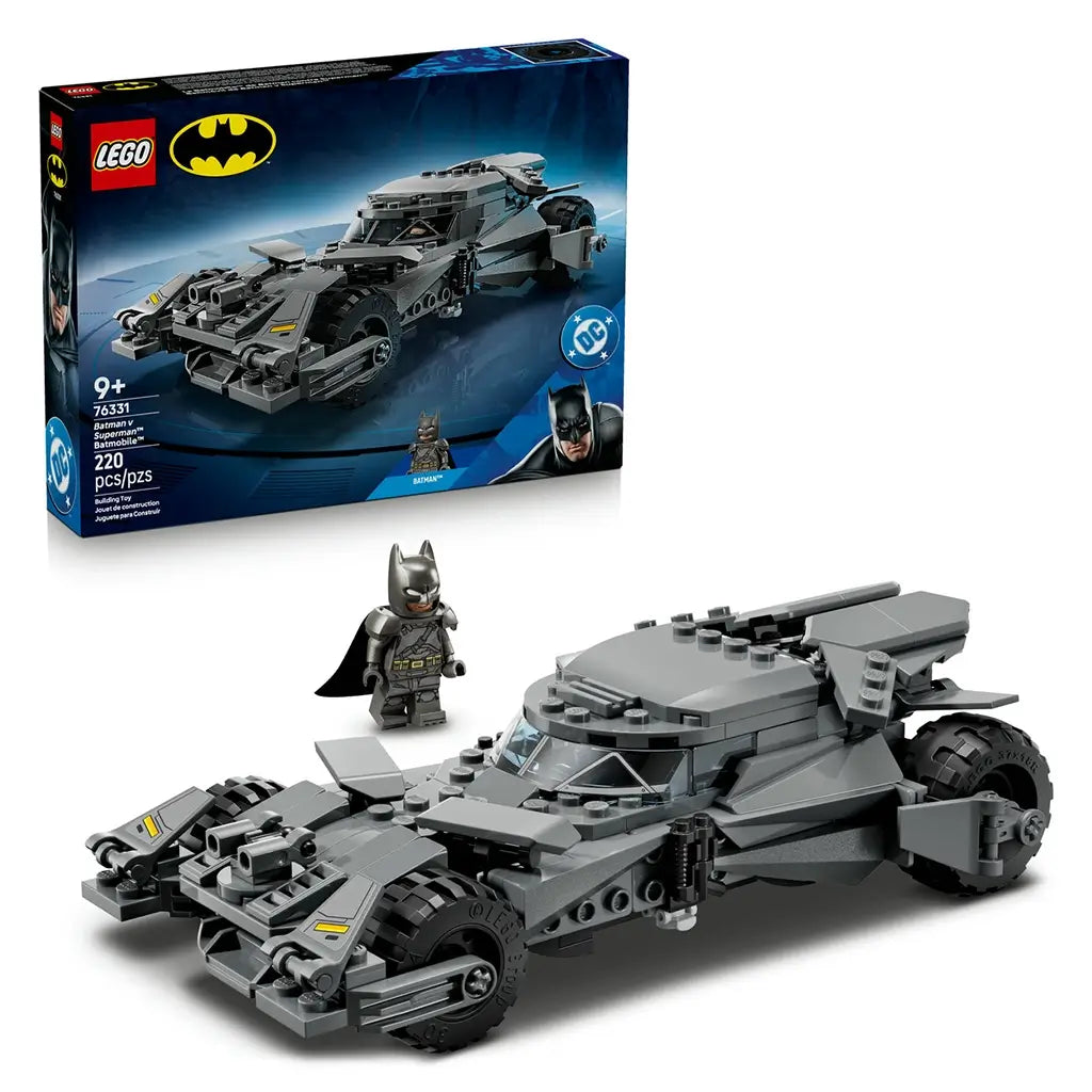 LEGO Batman Batmobile set in dark gray plastic, angular armored car shape with rugged tires and cockpit canopy, superhero vehicle toy displayed with box packaging on a clean studio background.