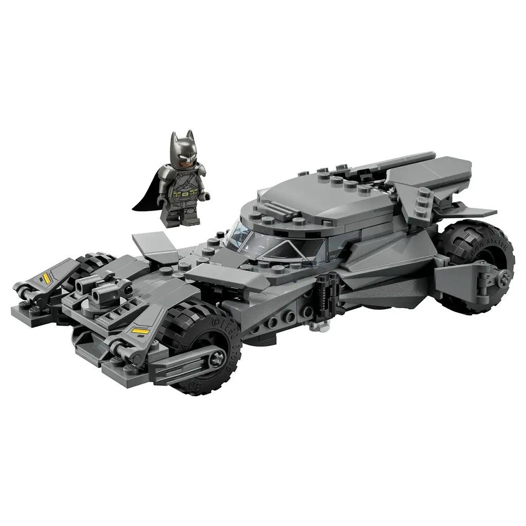 LEGO Batman Batmobile model in dark gray plastic with angular armored design and large rugged tires, detailed superhero car toy displayed with Batman minifigure on a plain white background.