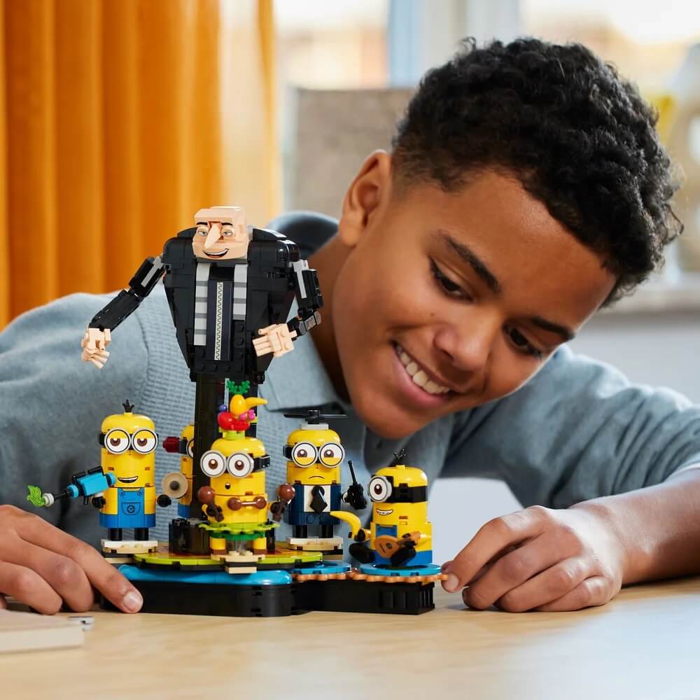 Boy wearing gray polo playing Lego Minions 