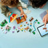 LEGO Disney Toy Story building set features colorful plastic pieces, farm accessories, animal figures and character parts spread around an opened ranch model beside a digital build guide.
