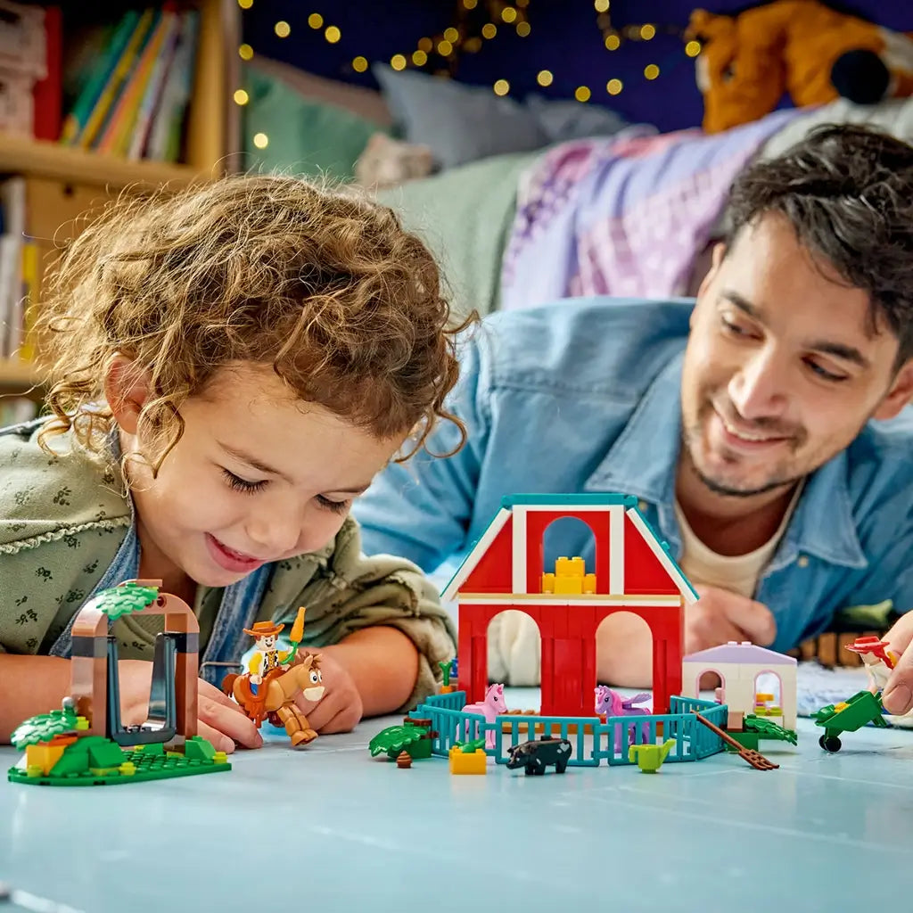 LEGO Disney Toy Story ranch playset features colorful plastic buildings, horse figures and character minifigures, creating imaginative farm adventures as children play indoors with an adult nearby.